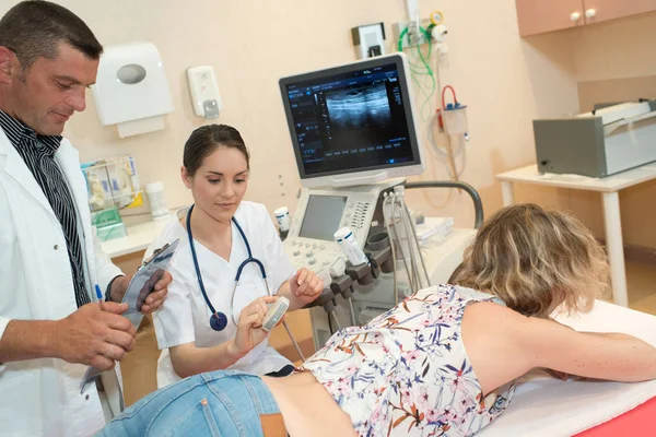 Läkare och patient undersökning tillbaka — Stockfoto