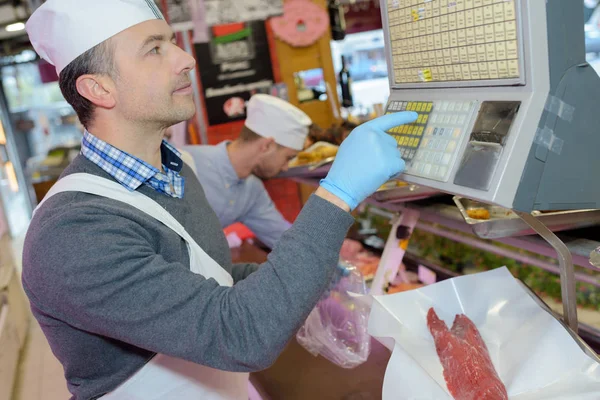 Macellaio che pesa carne su scaglie — Foto Stock