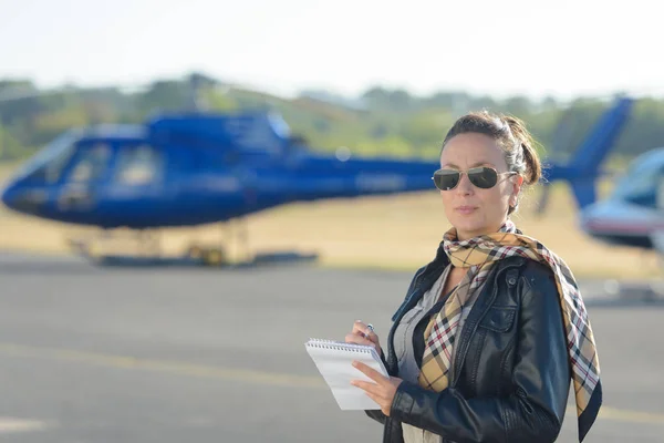 Vrij pilot vrouw op helikopter achtergrond — Stockfoto