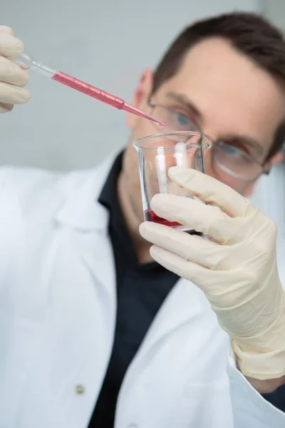Naukowiec pracujący w laboratorium z pipetą krwi — Zdjęcie stockowe