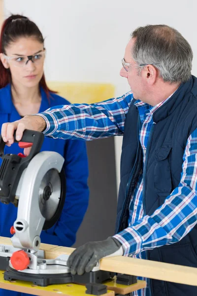 Vrouwelijke leerling met behulp van een cirkelzaag — Stockfoto