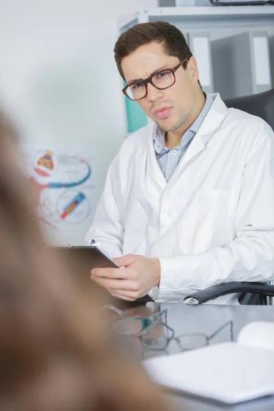 Doctor y paciente están discutiendo algo —  Fotos de Stock