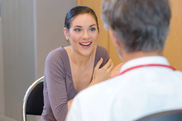 Щаслива жінка-пацієнтка з лікарем у клініці — стокове фото