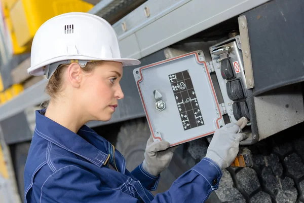 woman electrician engineer inspecting electric counter utdoors
