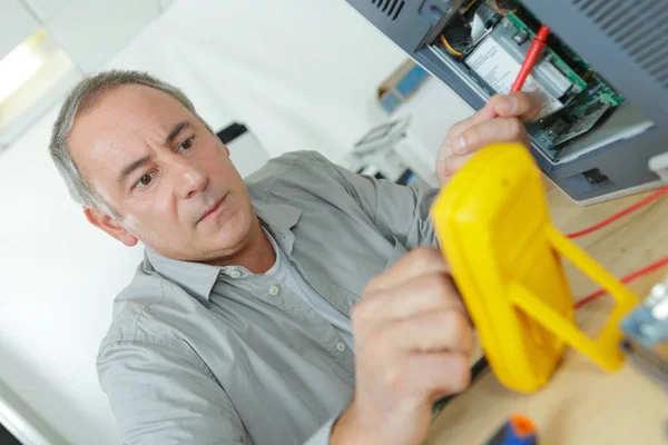Electrician checking voltage and — Stock Photo, Image
