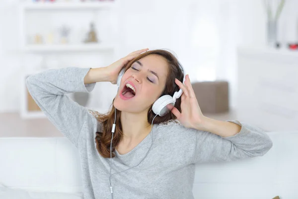 Vrouw met hoofdtelefoon schreeuwen met gesloten ogen — Stockfoto