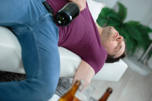 Inebriated man asleep on sofa — Stock Photo, Image