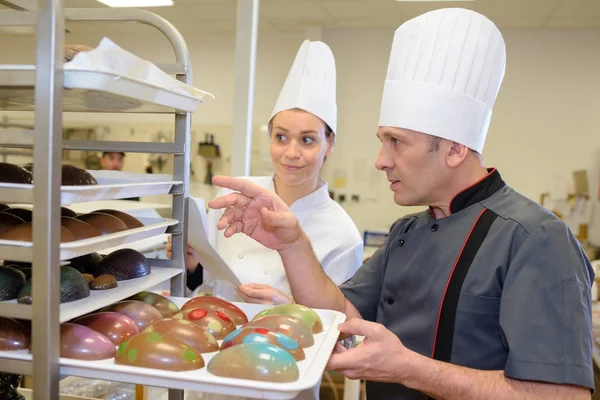 Bäckerin und Bäcker dekorieren Kuchen — Stockfoto