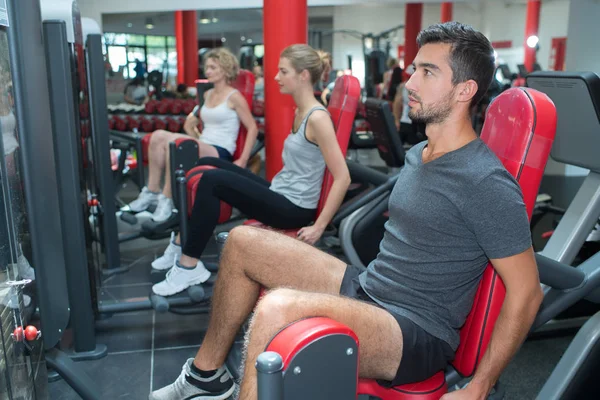 Groupe de personnes dans la salle de gym exerçant leurs jambes — Photo