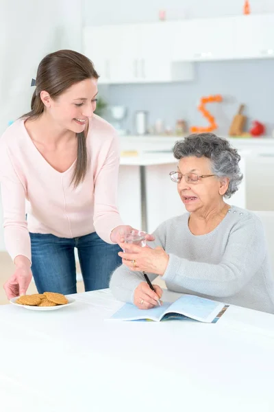 Pomoc młodym opiekunem starszy pani — Zdjęcie stockowe