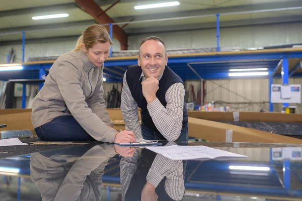 Frau und Manager mit Klemmbrett im Lager — Stockfoto