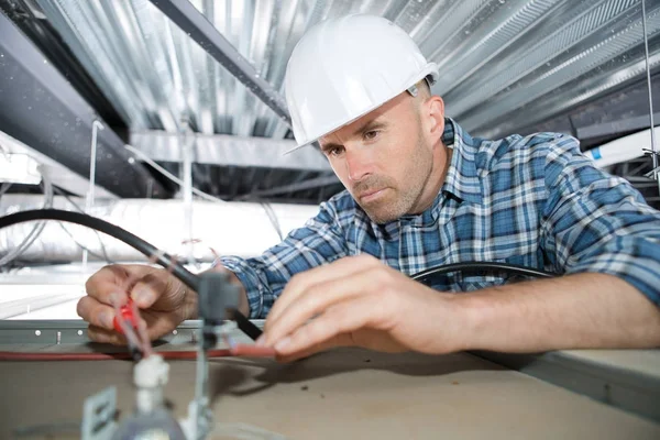 Elektricien bedrading in gebouw plafond — Stockfoto