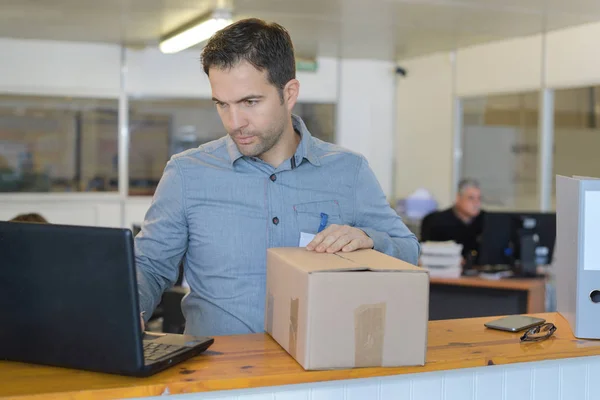 Mann im Büro erhält eine Lieferung — Stockfoto