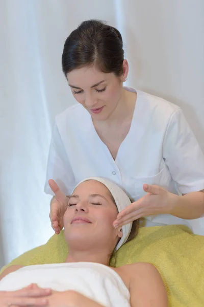 Hermosa chica joven teniendo masaje facial en el salón de spa —  Fotos de Stock