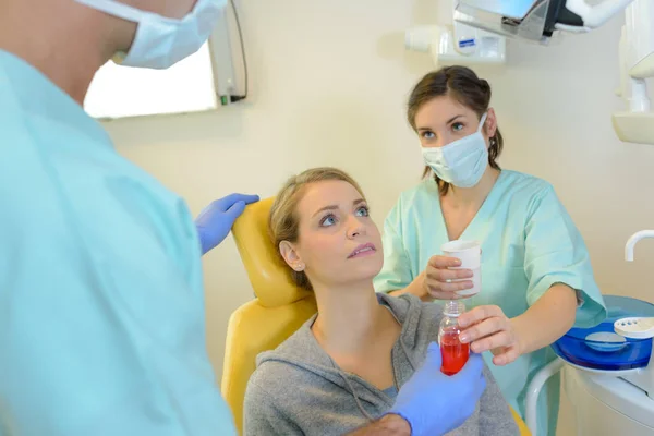 Zahnarzt heilt Patientin in der Zahnarztpraxis — Stockfoto