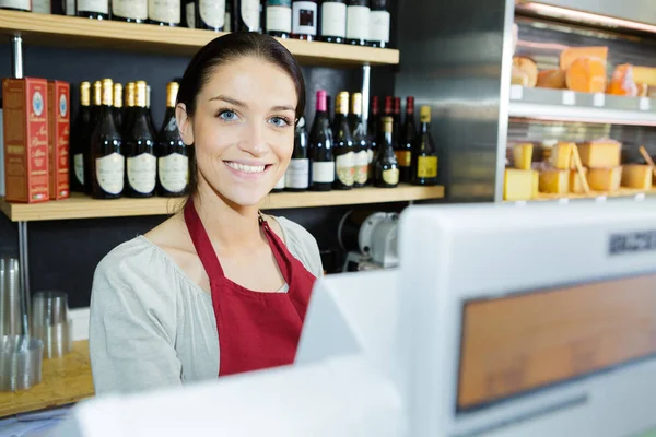 Mujer feliz vendiendo queso fresco en la tienda — Foto de Stock