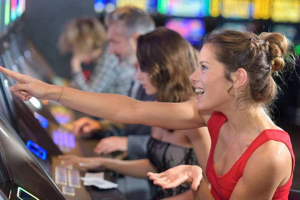 Vrouw zitten op slot machine in casino — Stockfoto