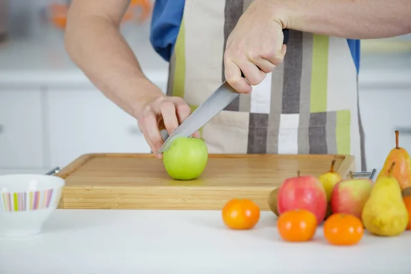 Någon är skära äpple på skärbrädan — Stockfoto