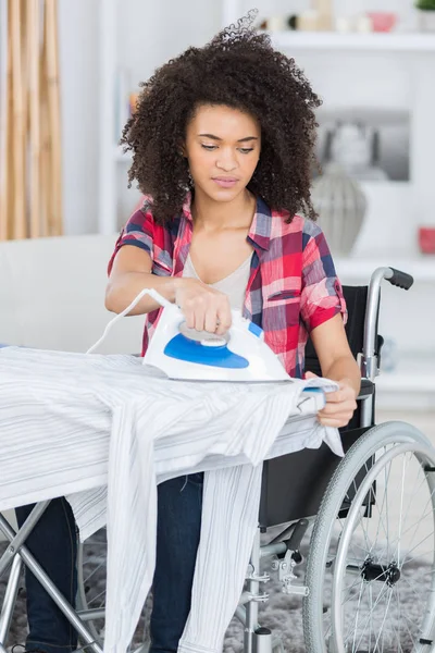 Άτομα με ειδικές ανάγκες γυναίκα κάνει κάποια σιδέρωμα — Φωτογραφία Αρχείου