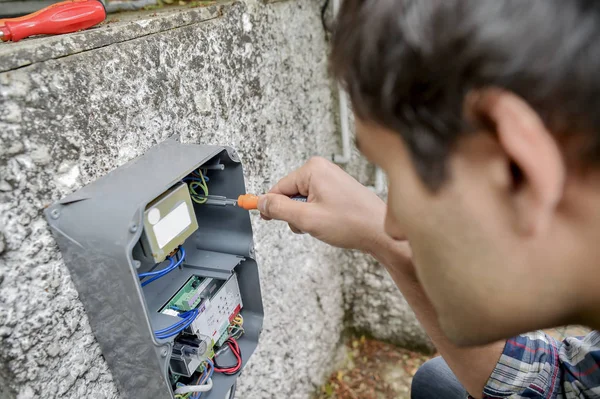 Mann fixiert Meter und jung — Stockfoto