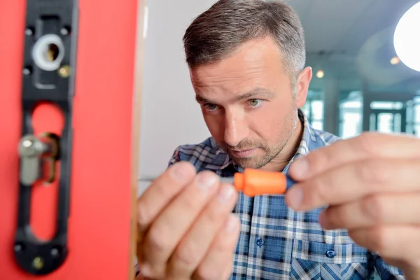 Man fitting new door lock