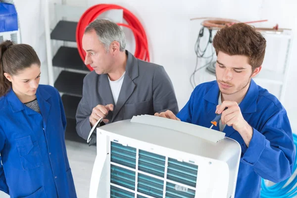 Airconditioning reparateur met leerlingen — Stockfoto