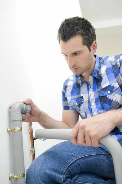 Plumber carefully fitting a pipe — Stock Photo, Image