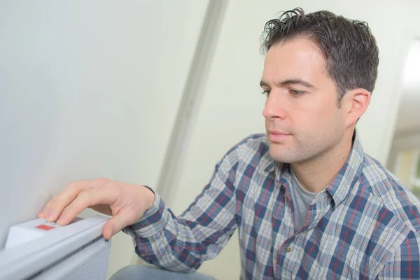 Hombre que ajusta la temperatura del termostato del radiador — Foto de Stock