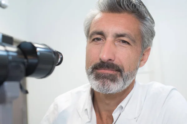 Gros plan du travailleur de laboratoire à côté de l'oculaire du microscope — Photo