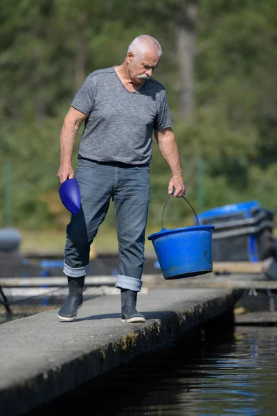 Промышленный рыбопромышленник, держащий рыбу в руках — стоковое фото