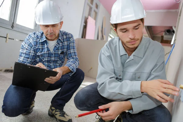 Zwei Bauarbeiter mit Tablet-Computern im Haus — Stockfoto