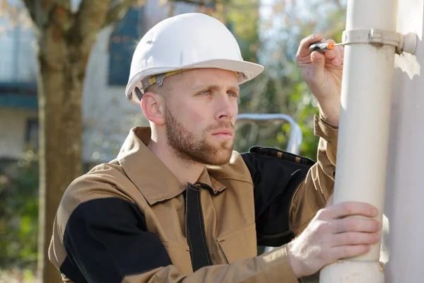 Klempner installiert neues Ventil an einem Rohr außerhalb des Hauses — Stockfoto