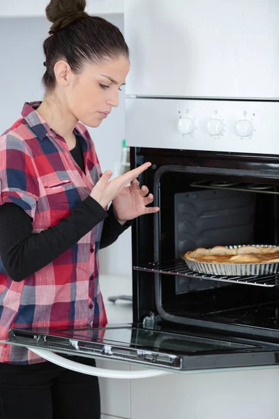 Joven mujer quemado mano mientras cocinar — Foto de Stock