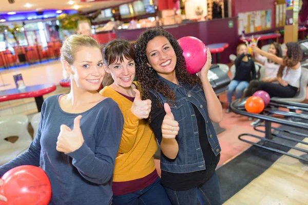 Kvinnor med tummen upp i bowling hall — Stockfoto