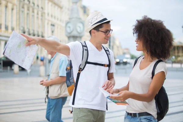 Happy tourists with map sightseeing city — Stock Photo, Image