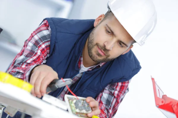 Elektricien snijdraad met een tang — Stockfoto