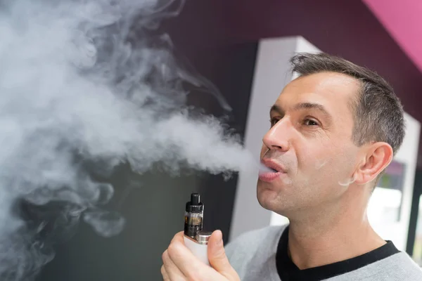 Man smokes electronic cigarette — Stock Photo, Image