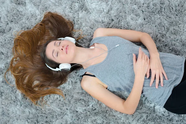 Young beautiful woman headphones listening music on the floor — Stock Photo, Image