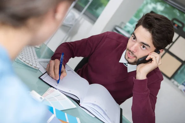 Confident male executive consulting client on phone — Stock Photo, Image