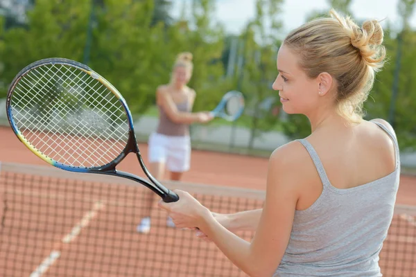 Two attractive women tennis players discussion at the court — стоковое фото