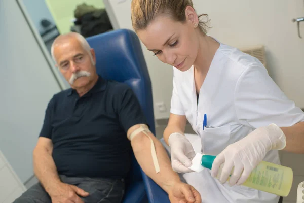 Läkaren testar blod till en äldre patient — Stockfoto