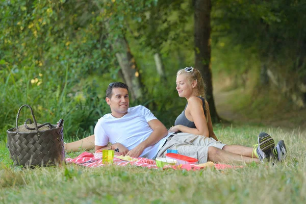 Casal relaxante em um piquenique — Fotografia de Stock