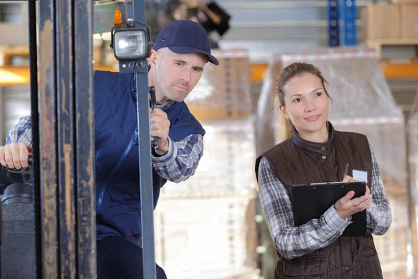 Lavoratore e manager che distribuiscono merci in un magazzino — Foto Stock