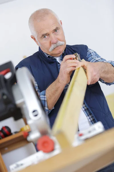 Mężczyzna carpenter jest cięcia drewna — Zdjęcie stockowe