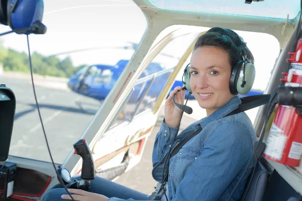 Pretty pilot woman in helicopter ready to takeoff — Stock Photo, Image