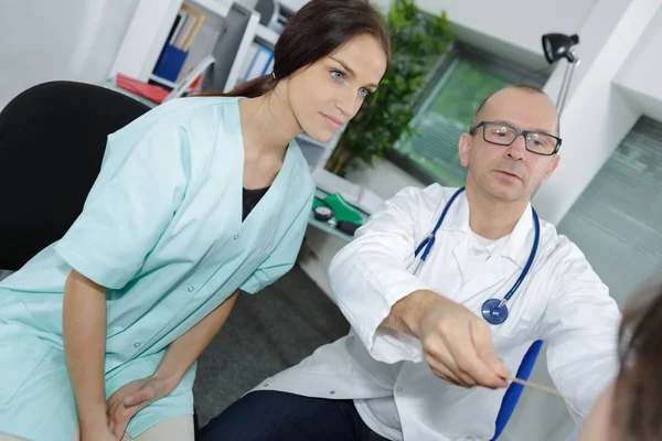 Médico senior y joven hermosa enfermera aprendiz —  Fotos de Stock