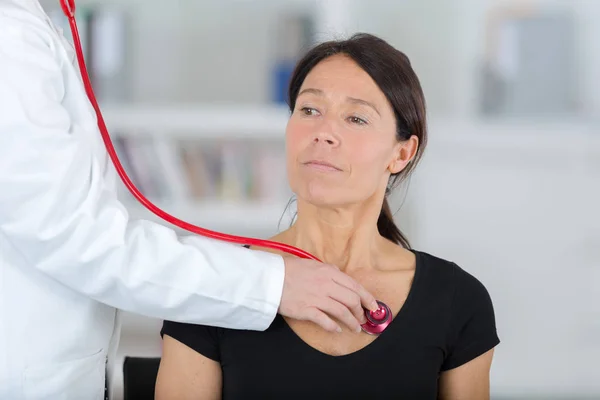 Médico feminino examinando o paciente com estetoscópio — Fotografia de Stock