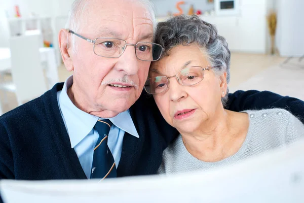 Стара пара читає газету — стокове фото