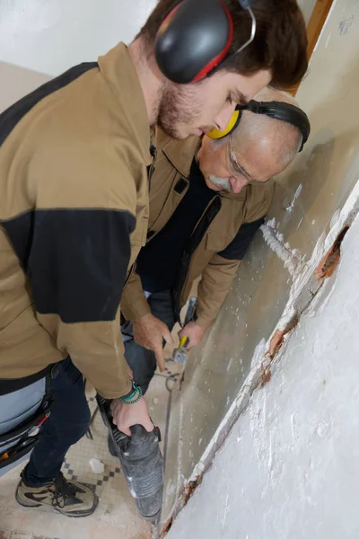 Lärling byggnadsarbetare använder en jackhammer — Stockfoto