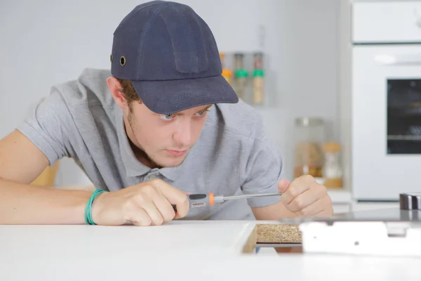 Jonge aannemer werkt in de keuken — Stockfoto